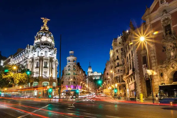 Noche en Gran Vía, Madrid. Edificios iluminados y luces de coches crean un ambiente vibrante. Un lugar ideal que ver en Madrid centro.