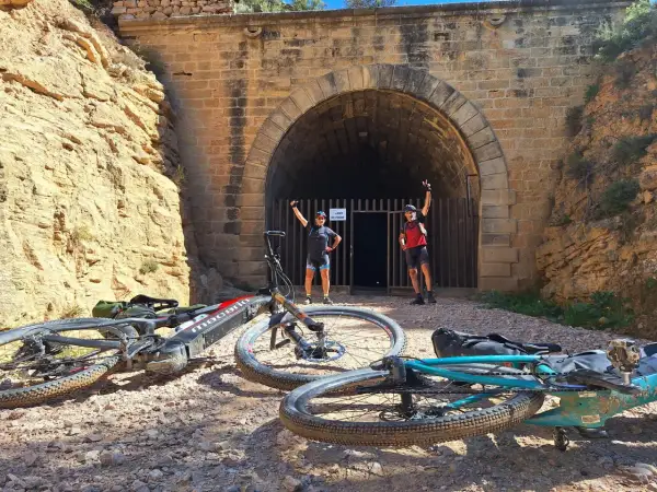 Ciclistas posan ante un túnel, una parada interesante que ver cerca de Alcañiz.