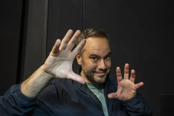 Jorge Blass Zaragoza, ilusionista, sonríe con las manos extendidas, listo para un truco.