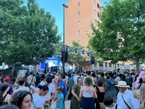Multitud disfrutando de las fiestas rosales del canal, con un concierto de "Los Gandules" en el escenario.