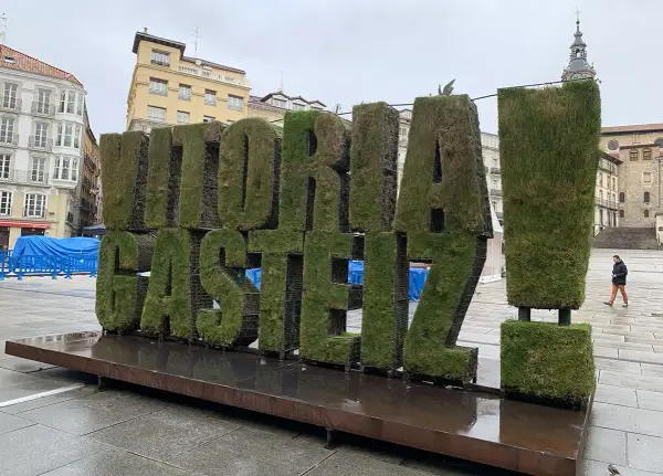 Letras gigantes cubiertas de césped con "VITORIA-GASTEIZ" en una plaza. ¡Un lugar genial que ver en Vitoria!
