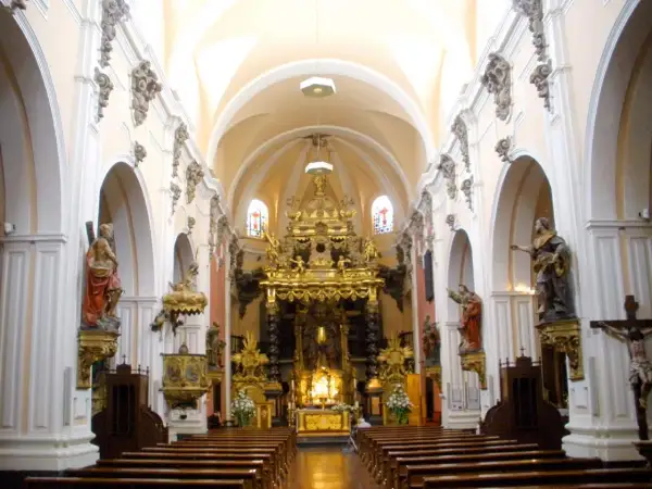 Interior de la iglesia san felipe zaragoza, con bancos de madera, un retablo dorado y estatuas de santos.
