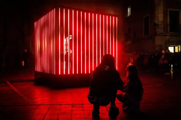 Dos personas observan una instalación de luces rojas en Zaragoza, un adelanto de lo que Zaragoza luce 2026.