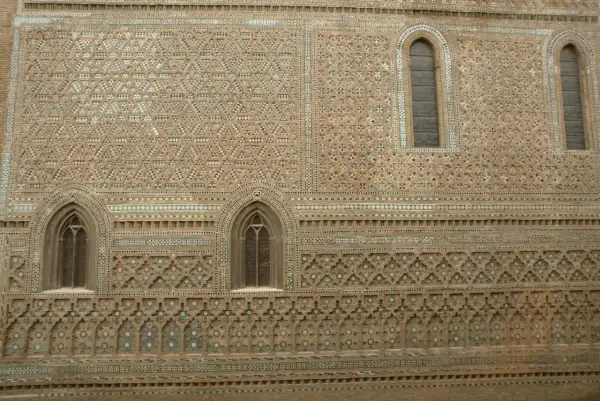 Detalle de la fachada de la parroquieta de la Seo, con intrincados mosaicos de ladrillo y azulejos formando patrones geométricos y florales.