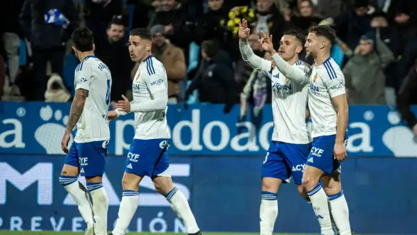 Jugadores de fútbol del Zaragoza celebran en el campo.