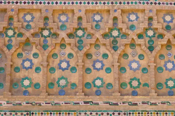 Detalle de azulejos de la Seo Zaragoza, con estrellas de ocho puntas en azul y verde sobre fondo de ladrillo y detalles circulares.
