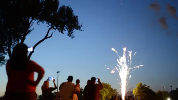 Gente observa fuegos artificiales, como en las mejores ferias de España.