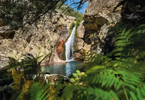 Cascada en un entorno rocoso y frondoso. Un lugar idílico que ver en Cáceres provincia para disfrutar de la naturaleza.