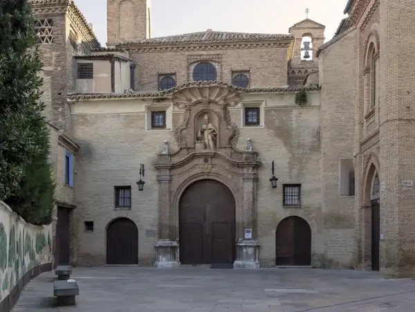 Fachada de la iglesia de las canonesas del Santo Sepulcro, con su gran portalón de madera y una escultura en el nicho central.