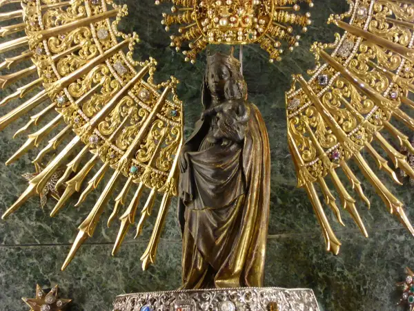Virgen con Niño, rodeada de un resplandor dorado y joyas, evocando la solemnidad de cuando es la Pilarica.